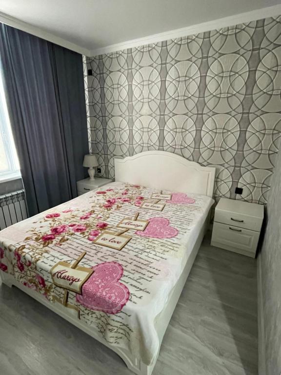 阿克套Апартаменты у Натальи的一间卧室配有带粉红色枕头的床。