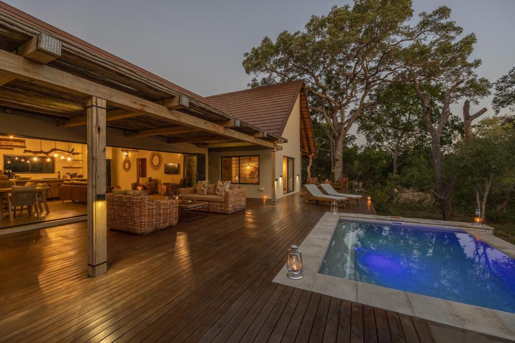 侯斯普瑞特Ukanyi Luxury Villa的一个带游泳池和房子的甲板