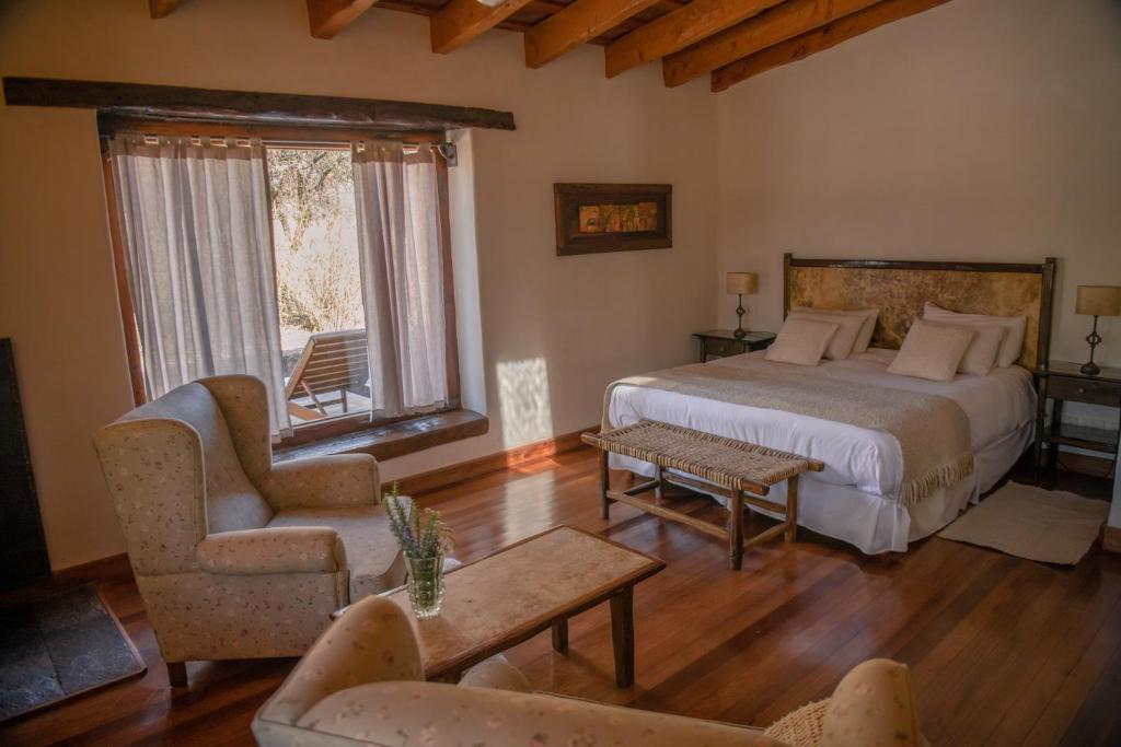 圣哈维尔Posada Rural La Matilde的一间卧室配有一张床、一张沙发和一把椅子