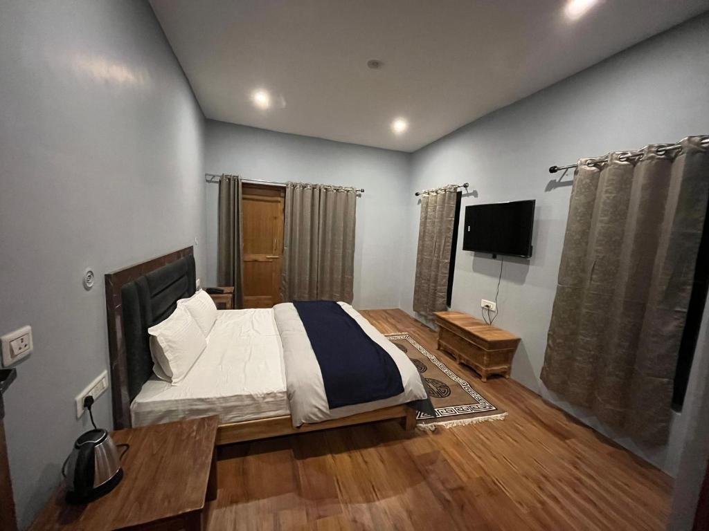 列城Honey Bee的一间卧室配有一张床和一台平面电视