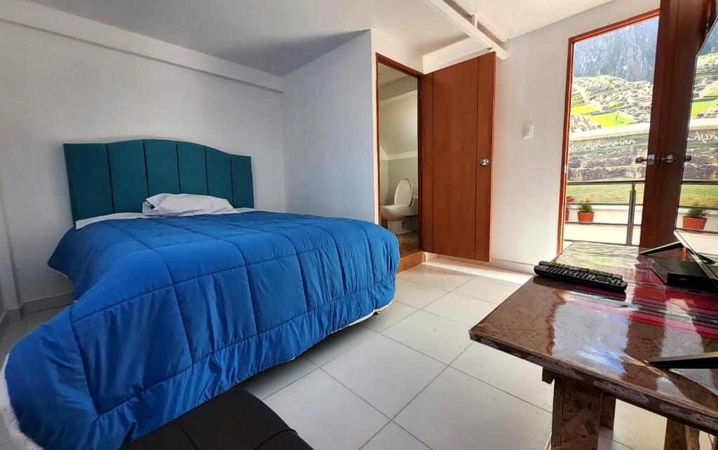 库斯科Peru Hostel Inn Plaza的一间卧室配有蓝色的床和一张书桌