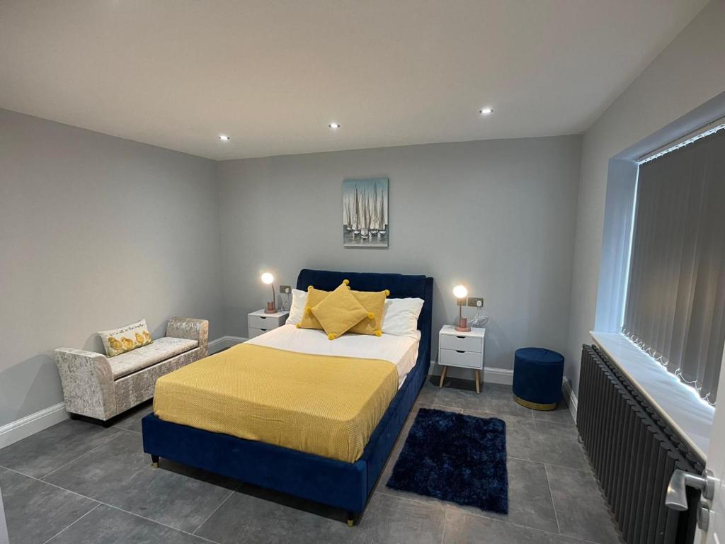 CanveyNewly refurbished 4 Bedroom House-Sleep 8-Free parking的一间卧室配有一张特大号床和一把椅子