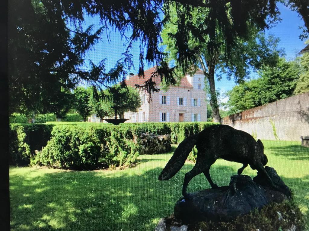 菲雅克Château de Bataillé的狗在草地上行走的雕像