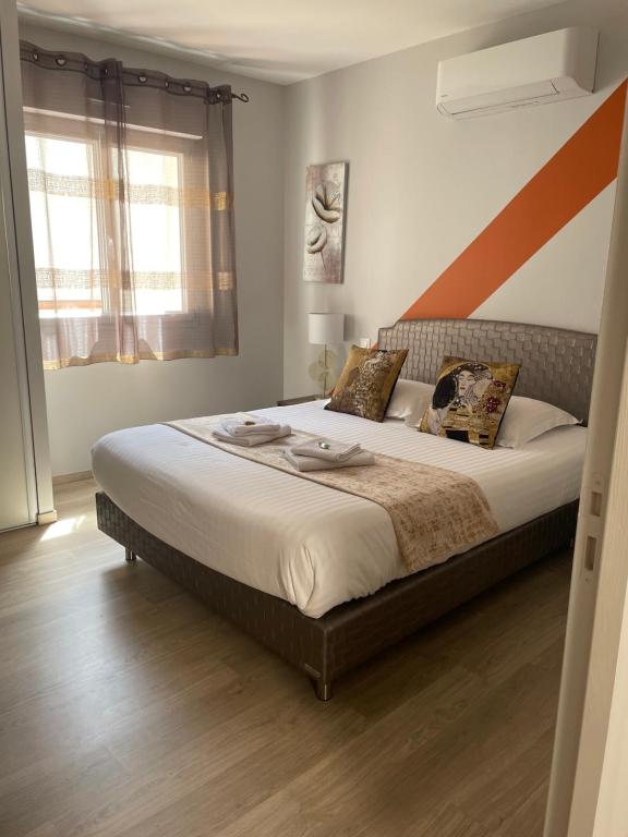 阿尔比Le Porta 5的卧室配有一张大床,墙上有橙色条纹