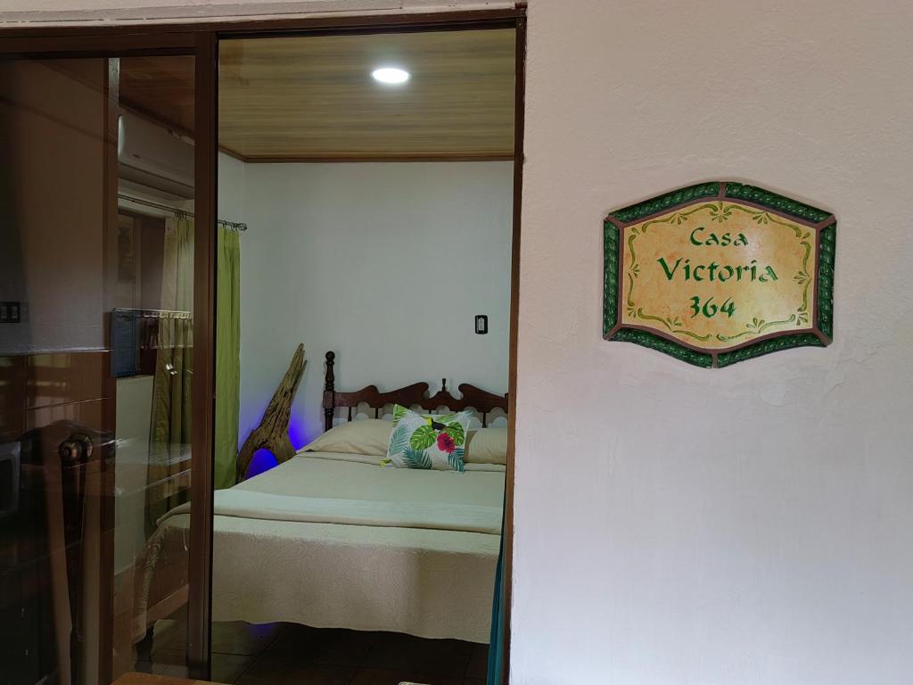 蓬塔雷纳斯Casa Victoria的卧室配有一张挂有墙上标志的床