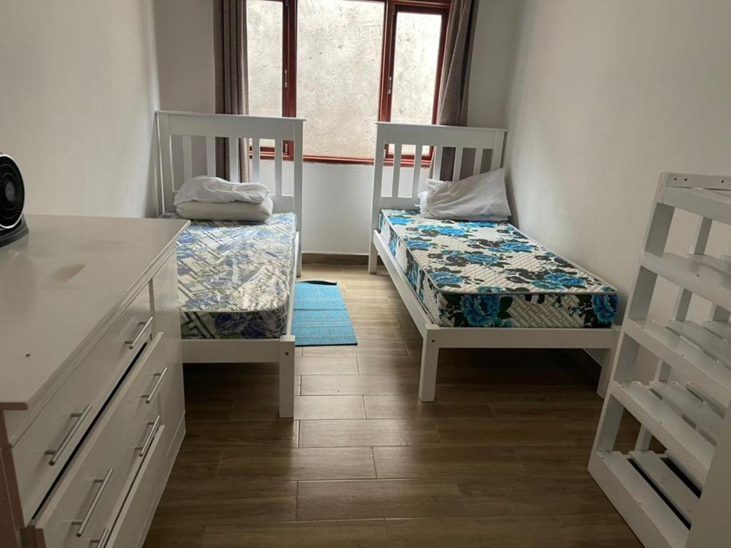 ShimwansaSerene & quiet 2- Bedroom Cottage Statelodge area的客房设有两张床和窗户。