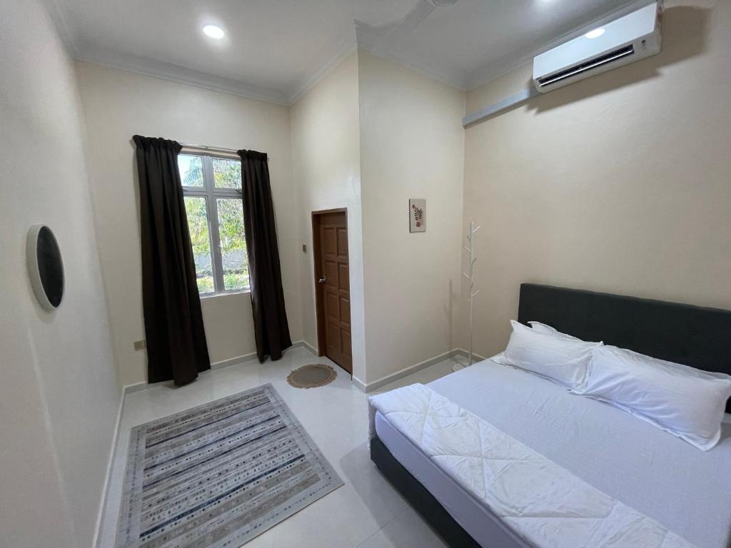 哥打巴鲁King's Cottage Homestay Kubang Kerian的卧室配有白色的床和窗户。