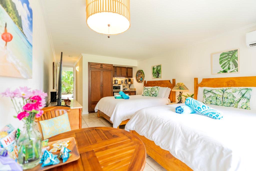 卡帕阿Islander Ocean Resort Condo # 166的一间卧室配有两张床和一张桌子