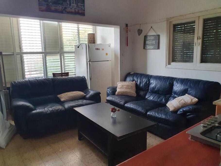 雷霍沃特2 bedroom apartment in batiya makov的客厅配有黑色真皮沙发和桌子