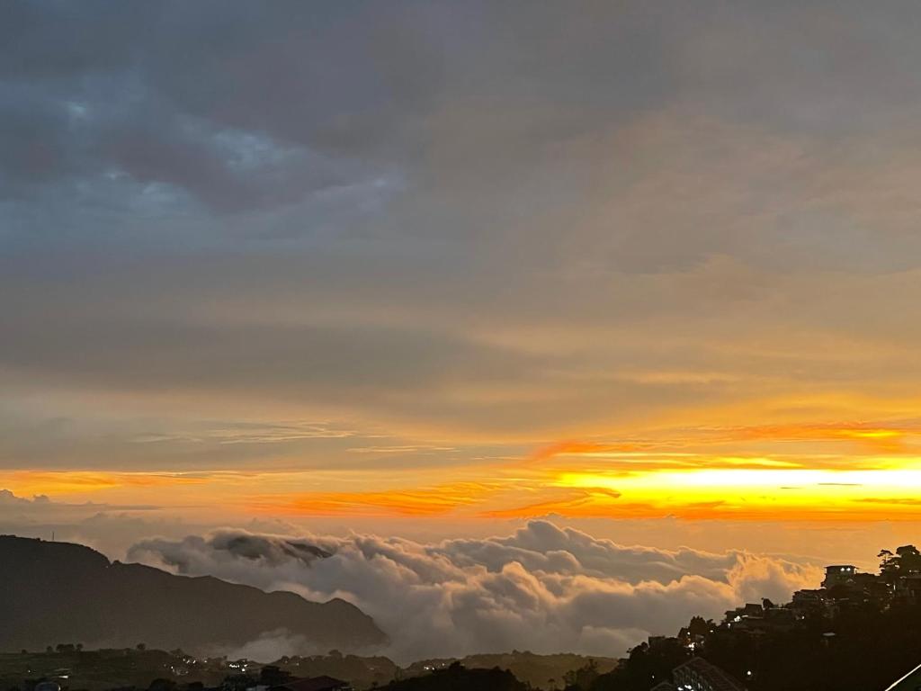 碧瑶Mountain and Sunsetview Baguio Residences的从云层上方欣赏日落美景