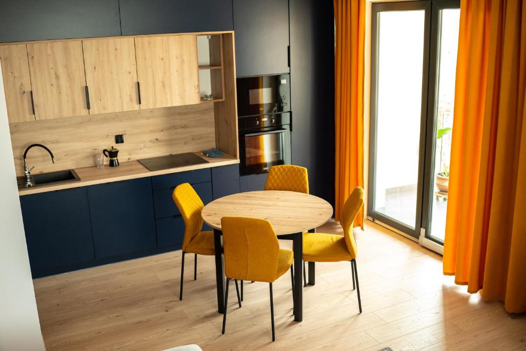 莱斯科Apartamenty Lesko 23的厨房配有木桌和黄色椅子
