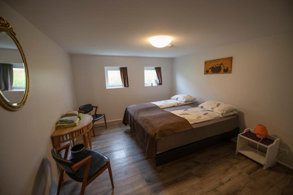 布伦迪欧斯Húnaver Guesthouse的一间卧室配有一张床、一张桌子和一面镜子
