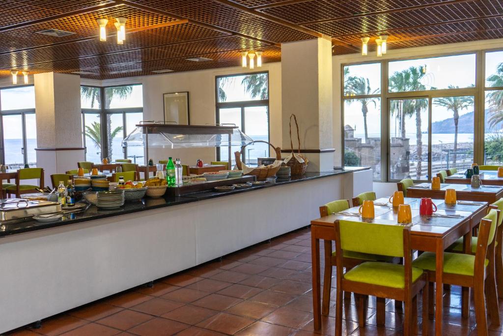 里韦拉布拉瓦Flag Hotel Madeira - Ribeira Brava的一间带桌椅的餐厅以及一间自助餐