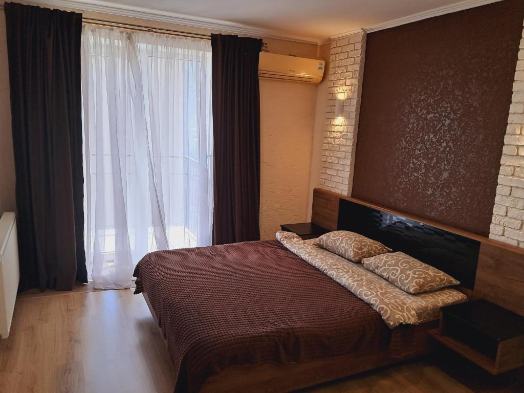 伊万诺-弗兰科夫斯克New modern apartments in the center的一间卧室设有一张床和一个大窗户