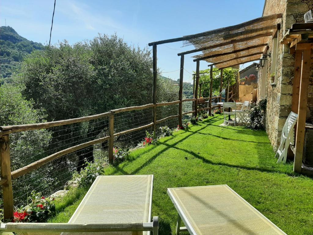 菲纳莱利古雷Contrada Bolla 2的草地上带桌子和长椅的花园