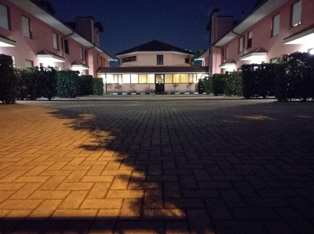 奥索纳Hotel Motel Europa的砖砌庭院上树的影子