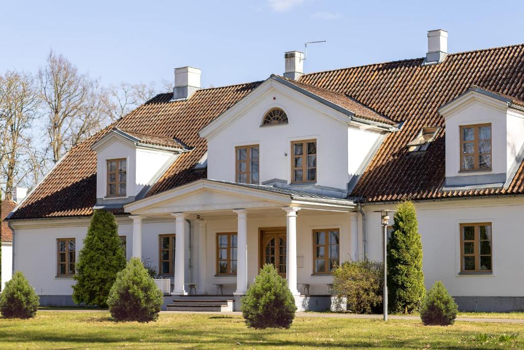 SkangaļiSkangaļu muiža的白色的大房子,设有瓷砖屋顶