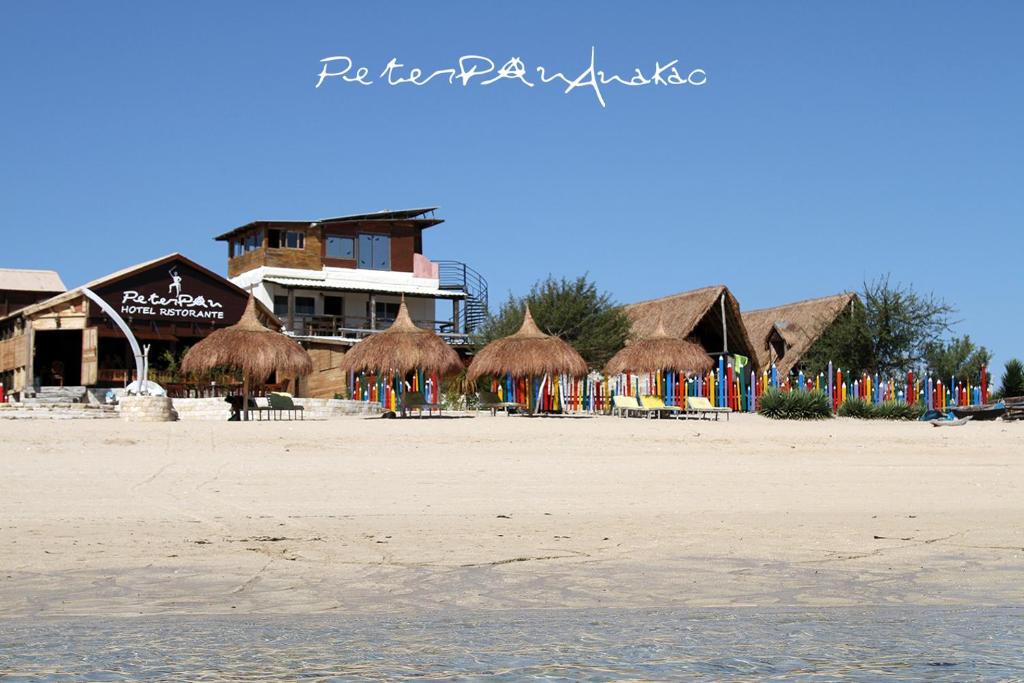 AnakaoChez Peter Pan Anakao的海滩上带草伞和椅子的海滩