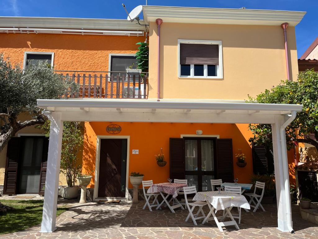普拉Villa Francesca的一座橙色房子前面配有桌椅
