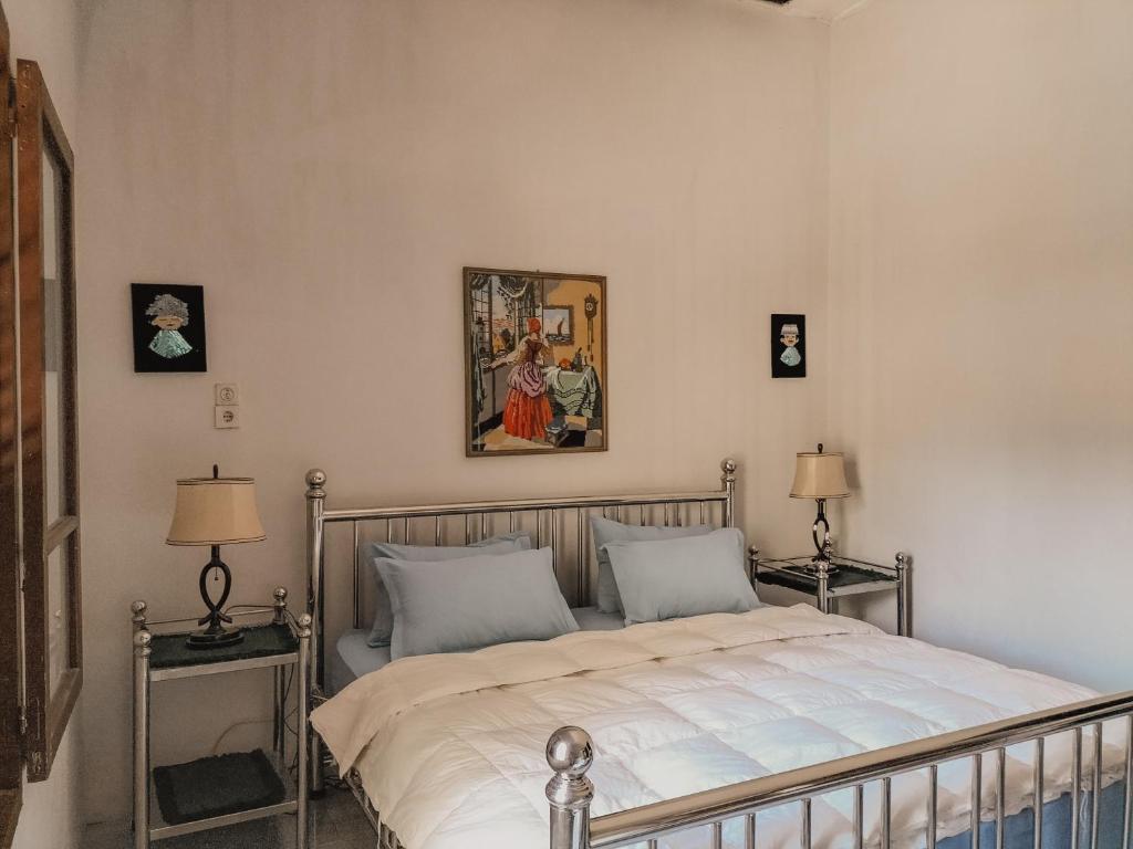 巴利盖BRUSSELS HOMESTAY BALIGE的一间卧室配有一张带两盏灯的床,墙上挂着一张照片