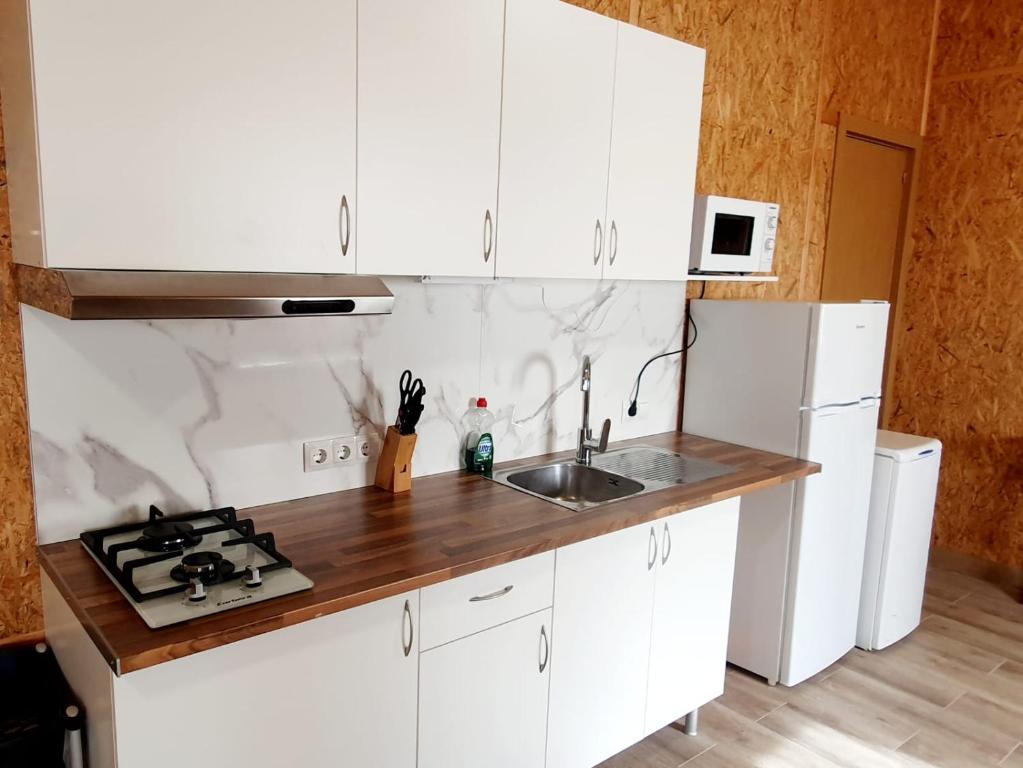 阿尔么丽亚Sol de Costacabana的厨房配有白色橱柜和水槽