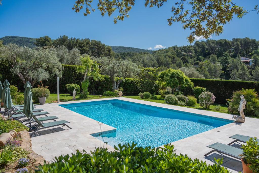 勒博塞Le Clos Serein的花园内的游泳池,花园内有椅子和树木