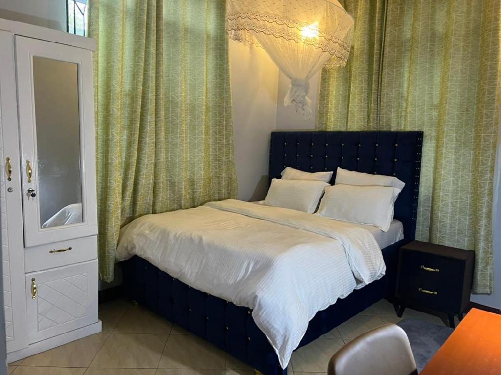 达累斯萨拉姆Romantic, Stunning & Authentic Ensuited Master Bedroom的一间卧室配有一张床和一个吊灯