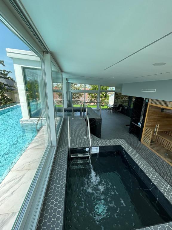希欧福克Villa Bauhaus Dream Deluxe T的室内按摩浴缸,位于带游泳池的房子内