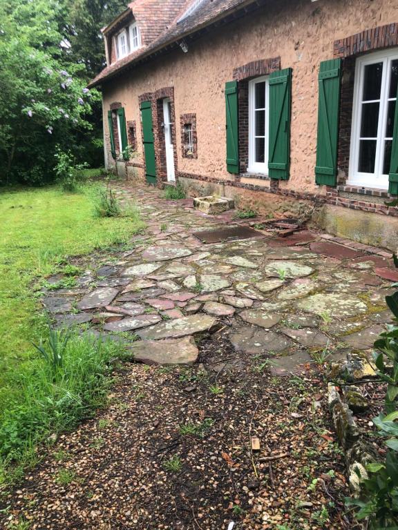 PontgouinChambre au calme的通往带绿色百叶窗的房子的石头路径