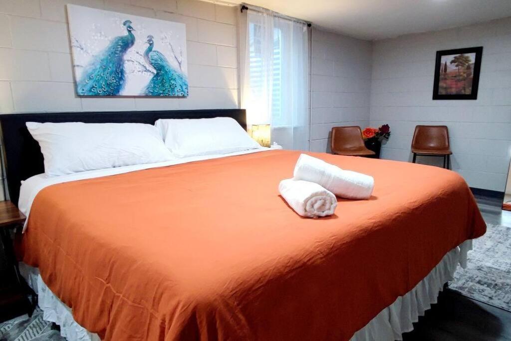 印第安纳波利斯Spacious Suite Close to Downtown Indy/ King Bed的一间卧室配有一张橙色大床和两条毛巾