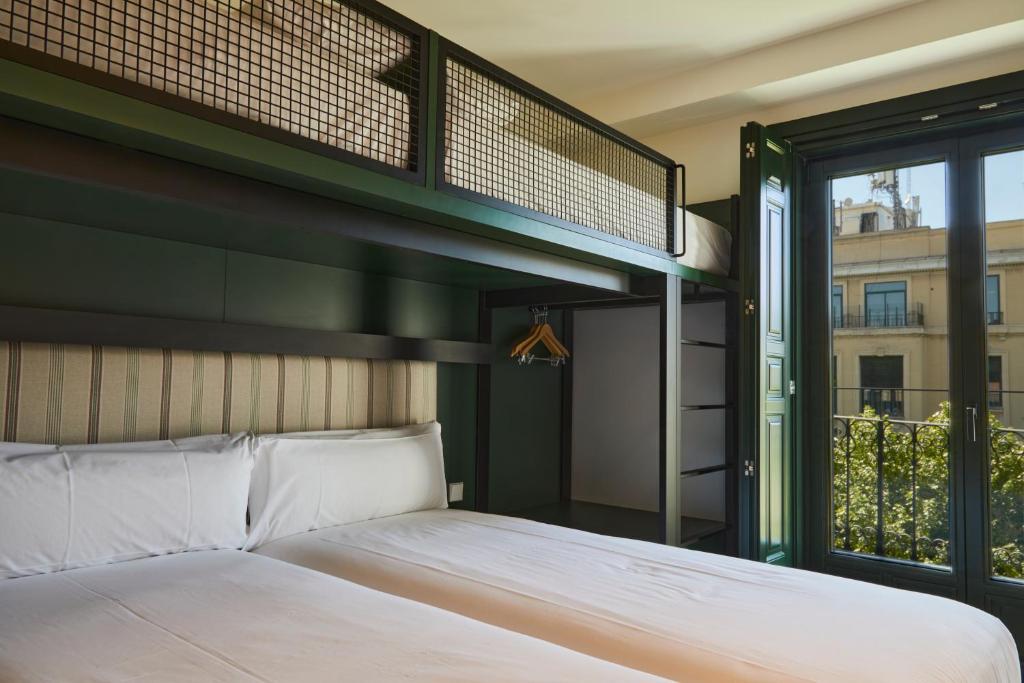 马德里LATROUPE Prado Hostel的一间卧室配有双层床和窗户。
