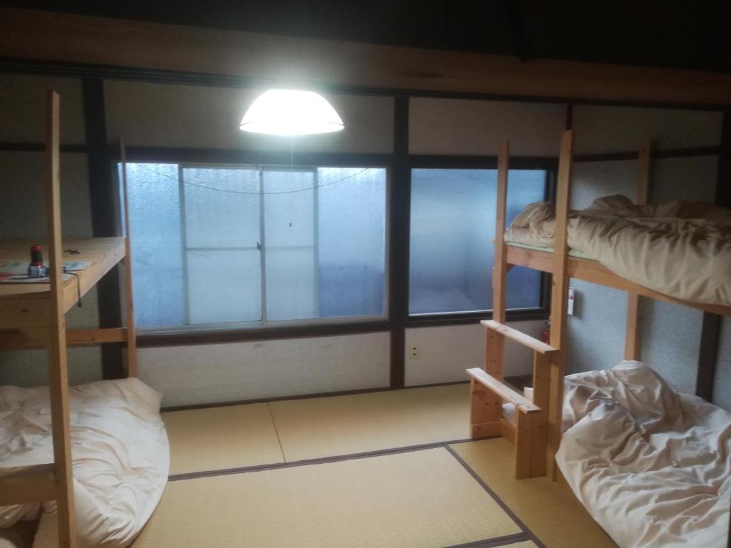 京都ez guest house的客房设有三张双层床和一扇窗户。