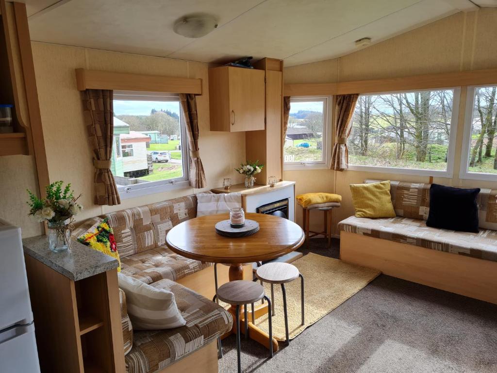 牛顿斯图尔特Loch Heron View的客厅配有沙发和桌子