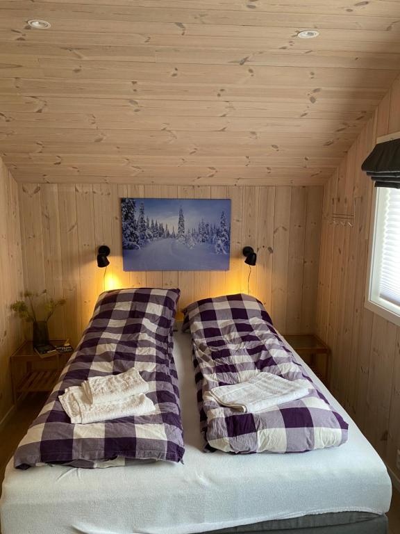 松达尔Fjelltun Lodge的小屋内一间卧室,配有两张床