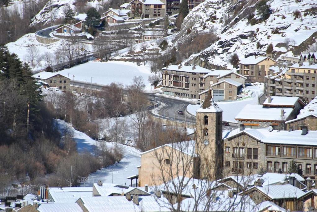 奥尔迪诺Appartement au coeur d'Ordino的雪中带钟楼的小城镇