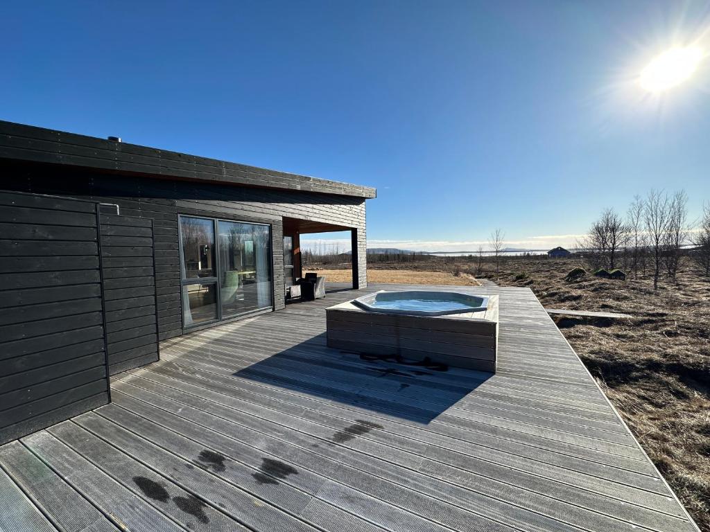 MiðdalurLuxury and Modern Cabin on the Golden Circle的木制甲板上设有热水浴池