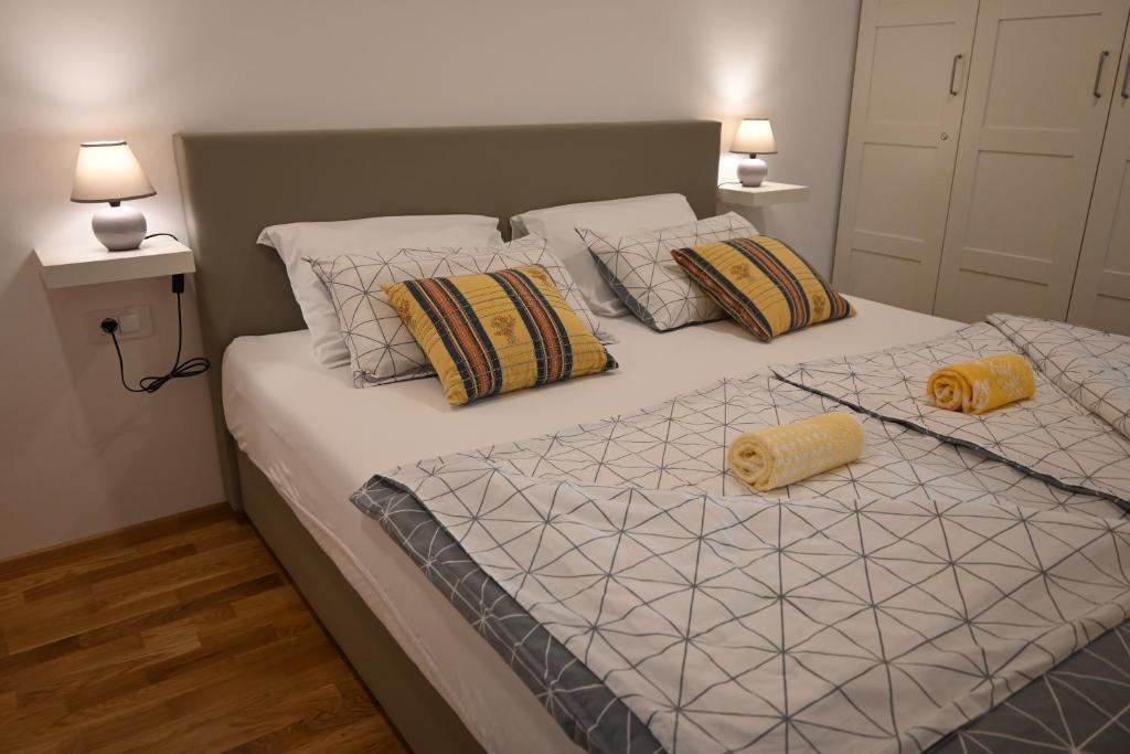 采尔克尼察Rest apartment Cerknica的一间卧室配有一张大床和两张黄色枕头
