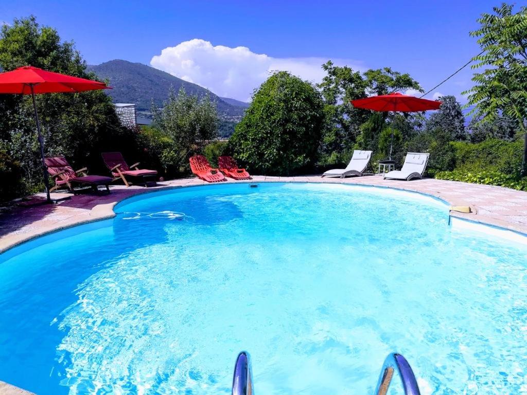 拉戈德Villa Côte d'Azur piscine privée的一个带椅子和遮阳伞的大型游泳池