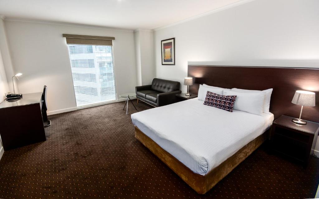 墨尔本墨尔本亚特兰蒂斯酒店 的配有一张床和一把椅子的酒店客房