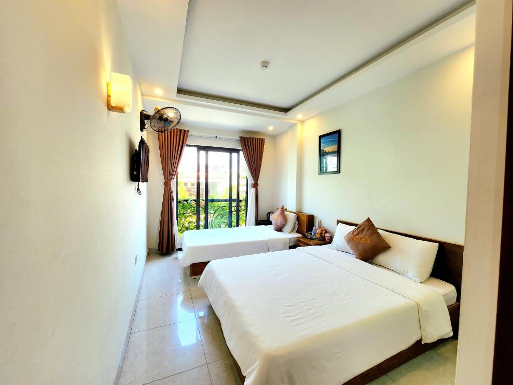归仁LaCas Hotel Quy Nhon的酒店客房设有两张床和窗户。