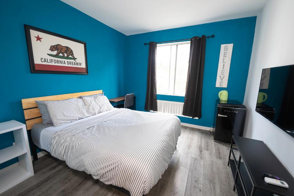 洛杉矶舒适好莱坞休养住宿加早餐旅馆的一间卧室设有一张床和蓝色的墙壁