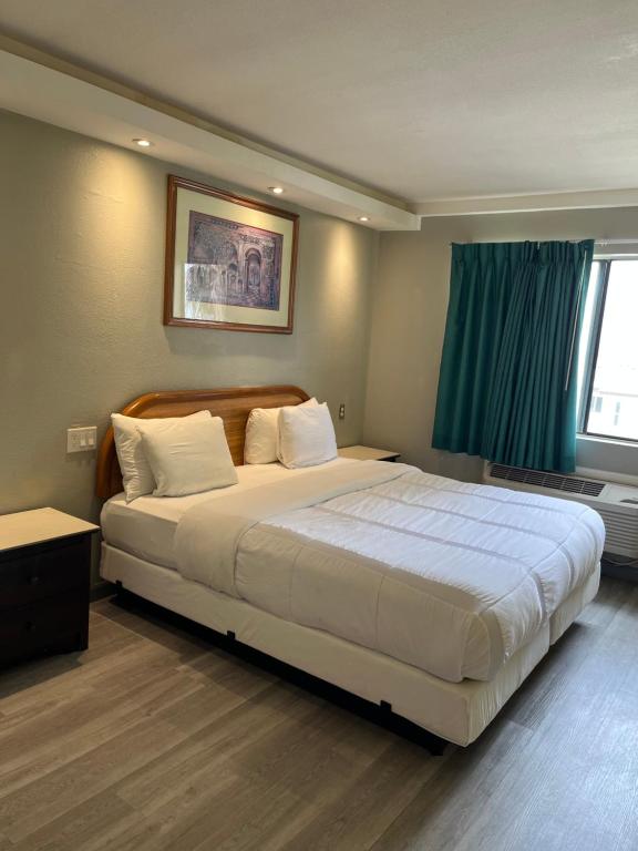 亨廷顿海滩777号汽车旅馆的卧室配有一张大白色床和窗户