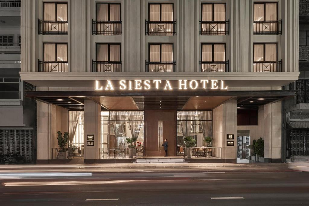 胡志明市La Siesta Premium Saigon的带有阅读la siesta酒店标志的酒店大楼