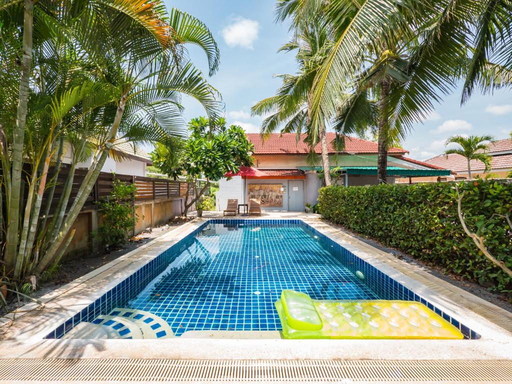 苏梅岛Lemon House apartment的棕榈树屋前的游泳池