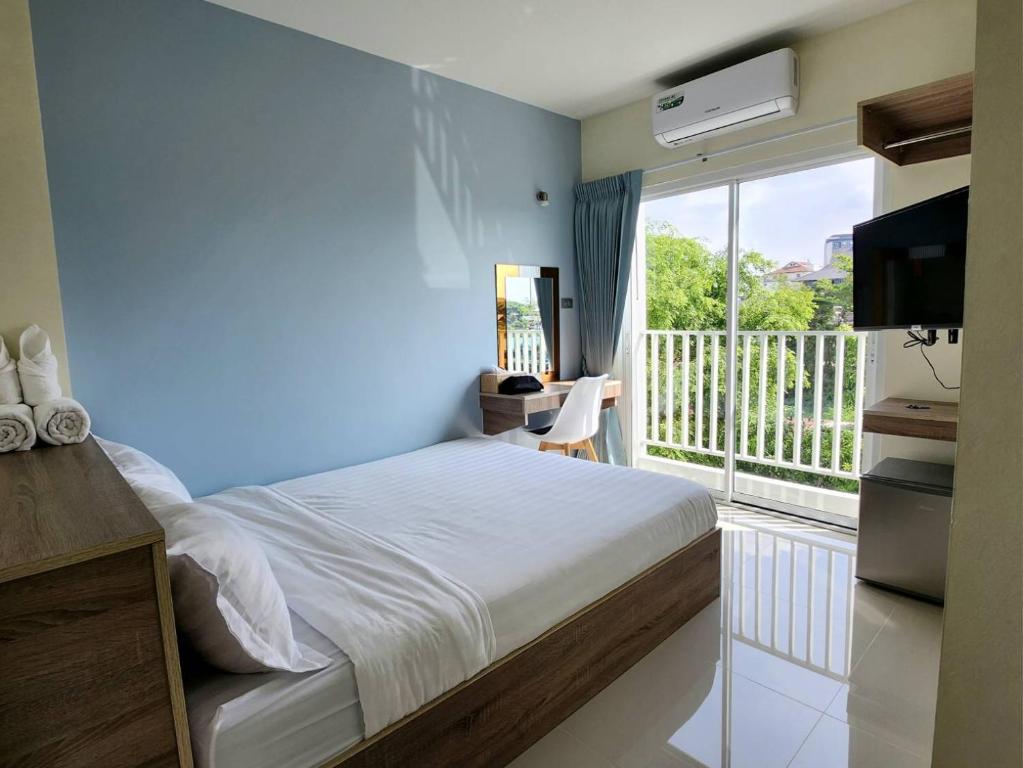 清迈98 Tower Chiang Mai的一间卧室设有一张床,阳台配有电视。