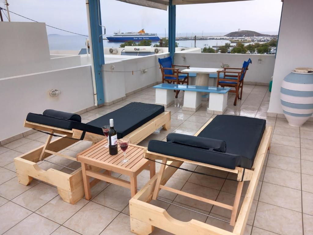 纳克索乔拉Katy's Home的阳台配有桌子、长凳和桌椅。