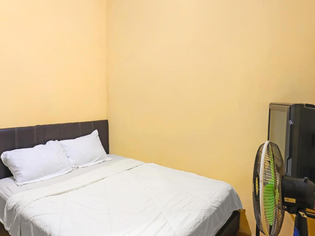 名古屋SPOT ON 92569 Anto Homestay Syariah的一间卧室配有一张床和一台电视。