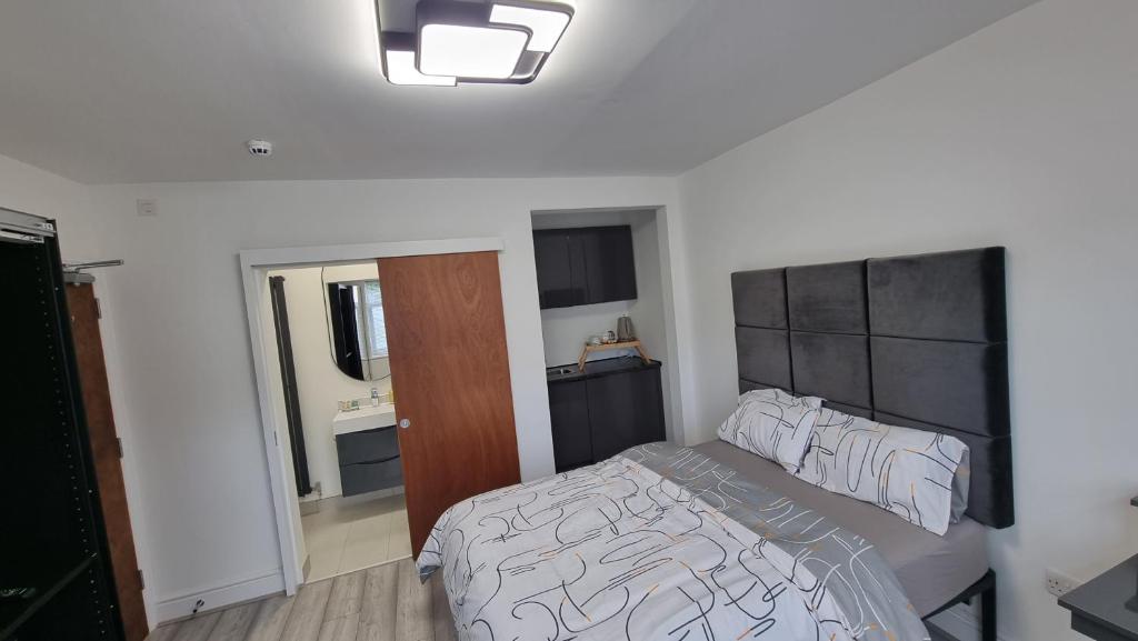 伦敦科尔尼Stylish Suites with kitchenette的一间卧室配有一张带黑白色棉被的床
