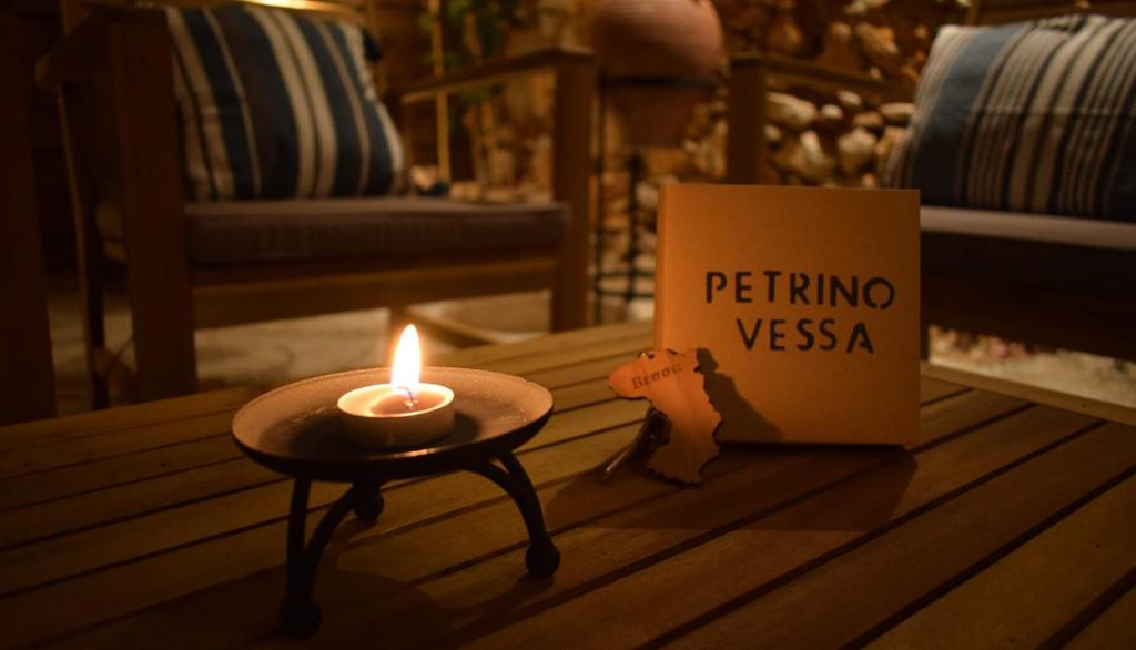 VéssaPetrino Vessa的坐在书旁边的桌子上的蜡烛