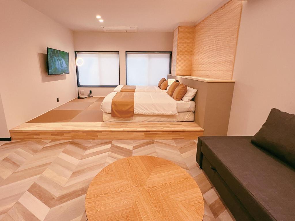 GotsuFELIZ ARIFUKU ONSEN的一间卧室配有一张床,铺有木地板